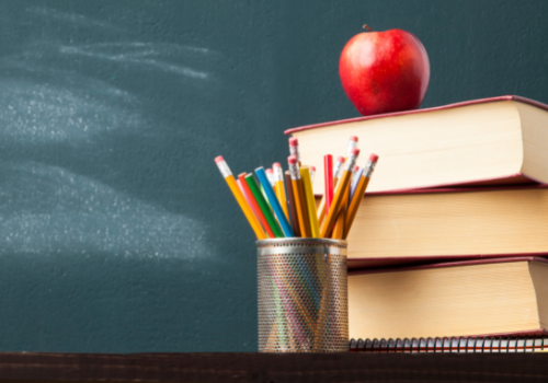 can of pencils in front of books
