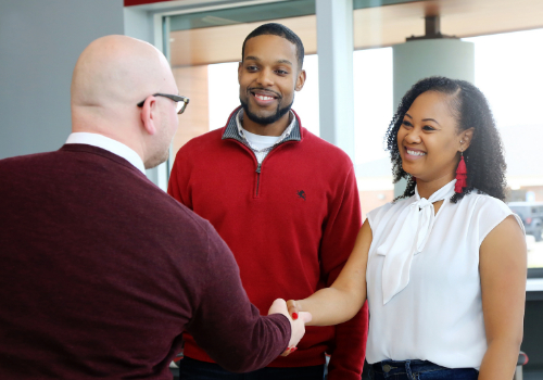 couple shaking hands with banker