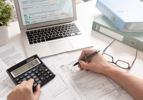 person working on taxes in front of their laptop